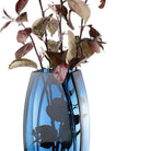 Blue-teal art glass vase with burgundy foliage