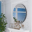 Venetian-style ornate round mirror on a white brick wall above a styled mantel