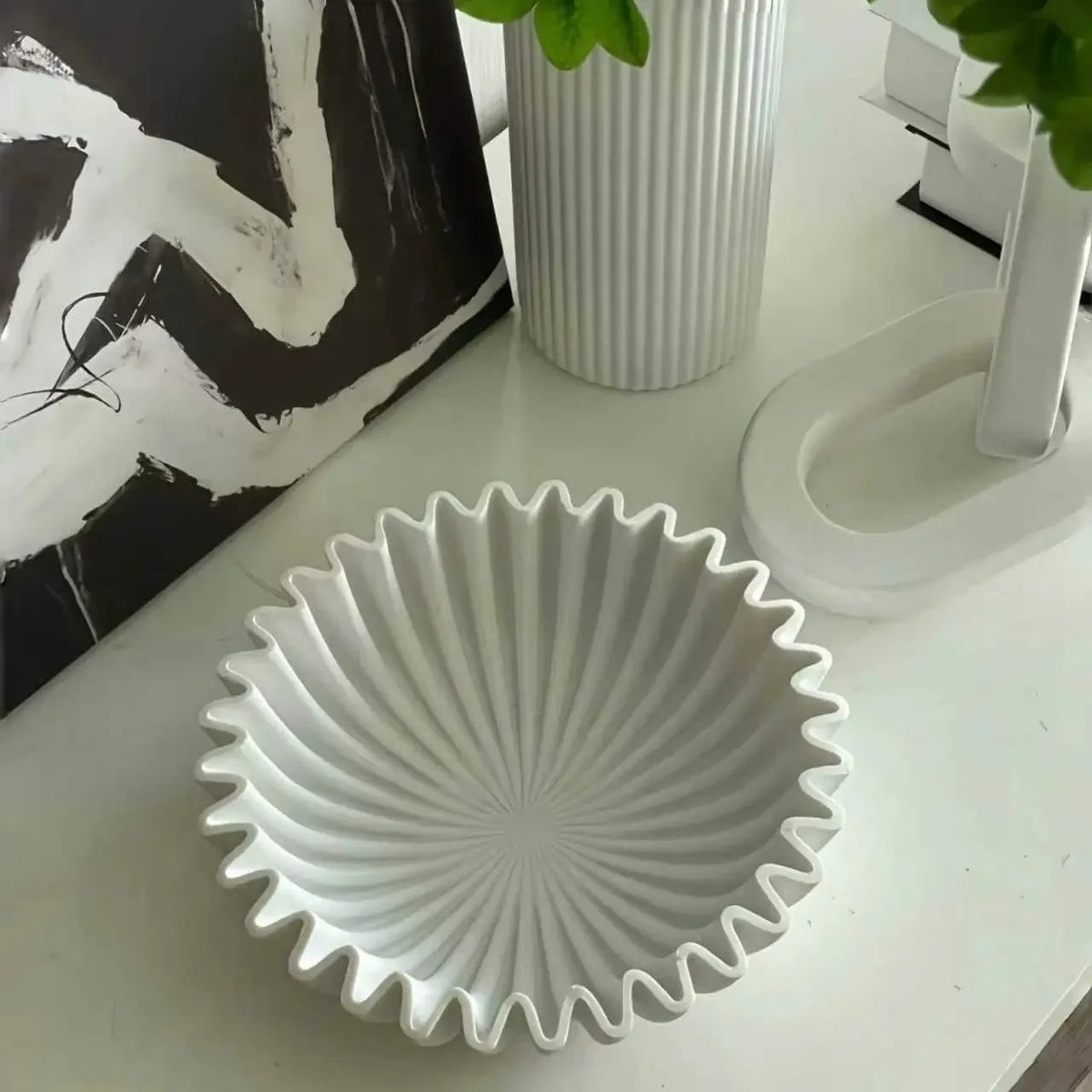 White pleated ceramic bowl with a scalloped rim on a vanity