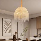 Crystal-look bead waterfall chandelier in gold hanging above a dining table