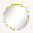 Front view of the wavy scalloped round mirror's thin gold frame on white