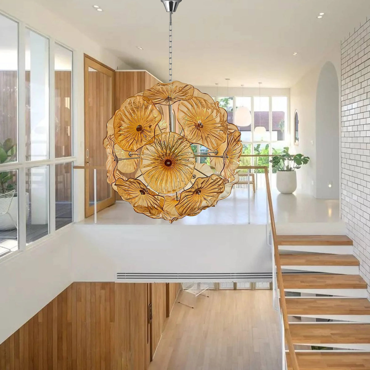 Amber glass flower chandelier above a white kitchen and stair