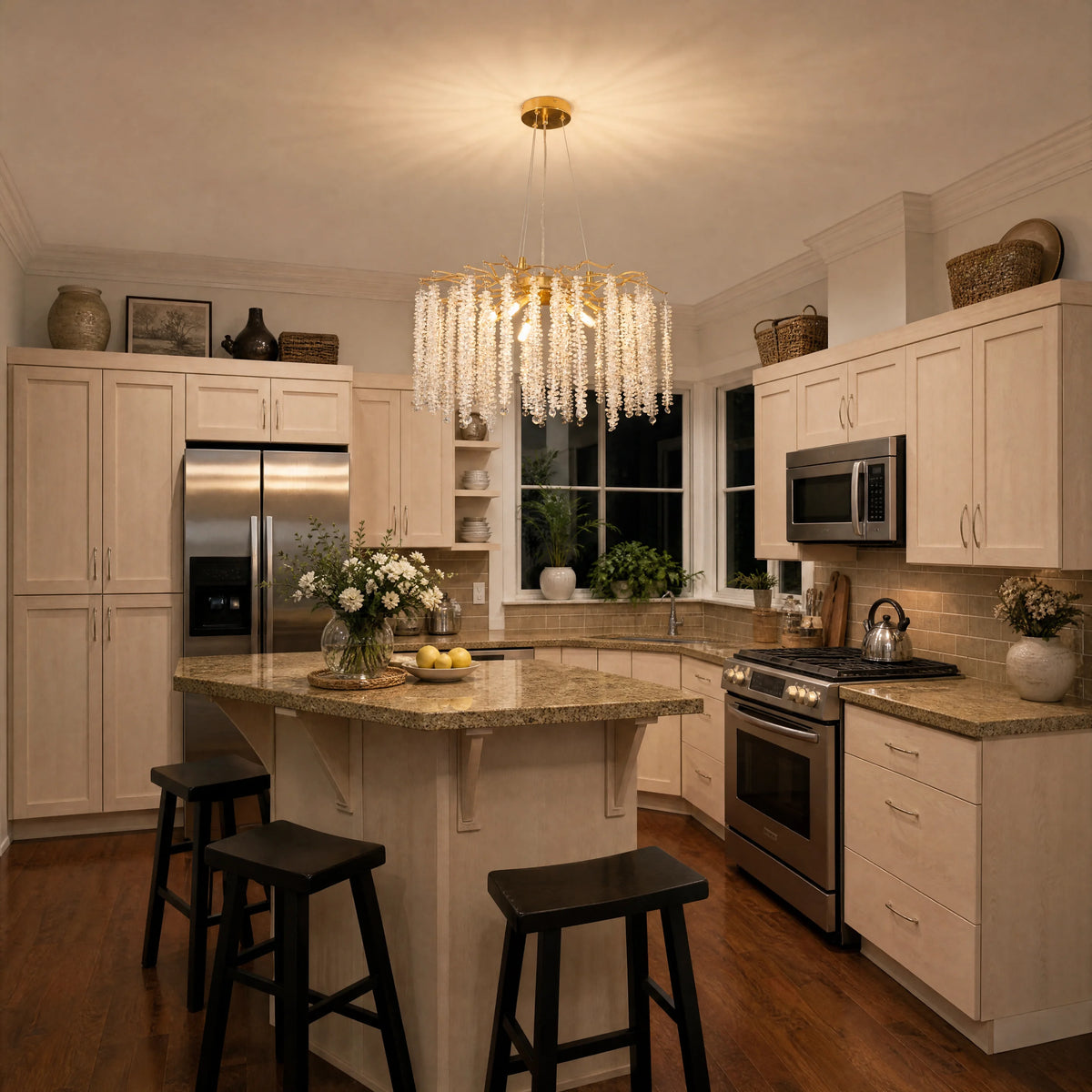 Gold branch raindrop crystal chandelier above a granite kitchen island with black stools