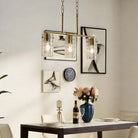 Brass three-light linear pendant with clear glass shades above a dining table