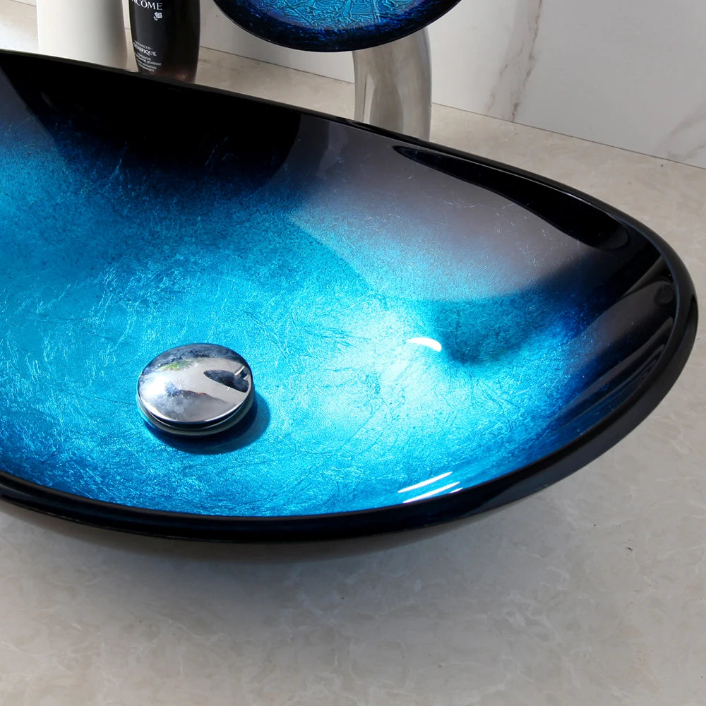 Ocean-blue gradient glass oval vessel sink with chrome pop-up drain, close-up