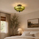Green petal glass ceiling light glowing in a bedroom