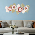 Pink and gold metal flower wall art above a sofa on a soft blue wall