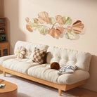 Blush and gold ginkgo leaf wall art above a white sofa