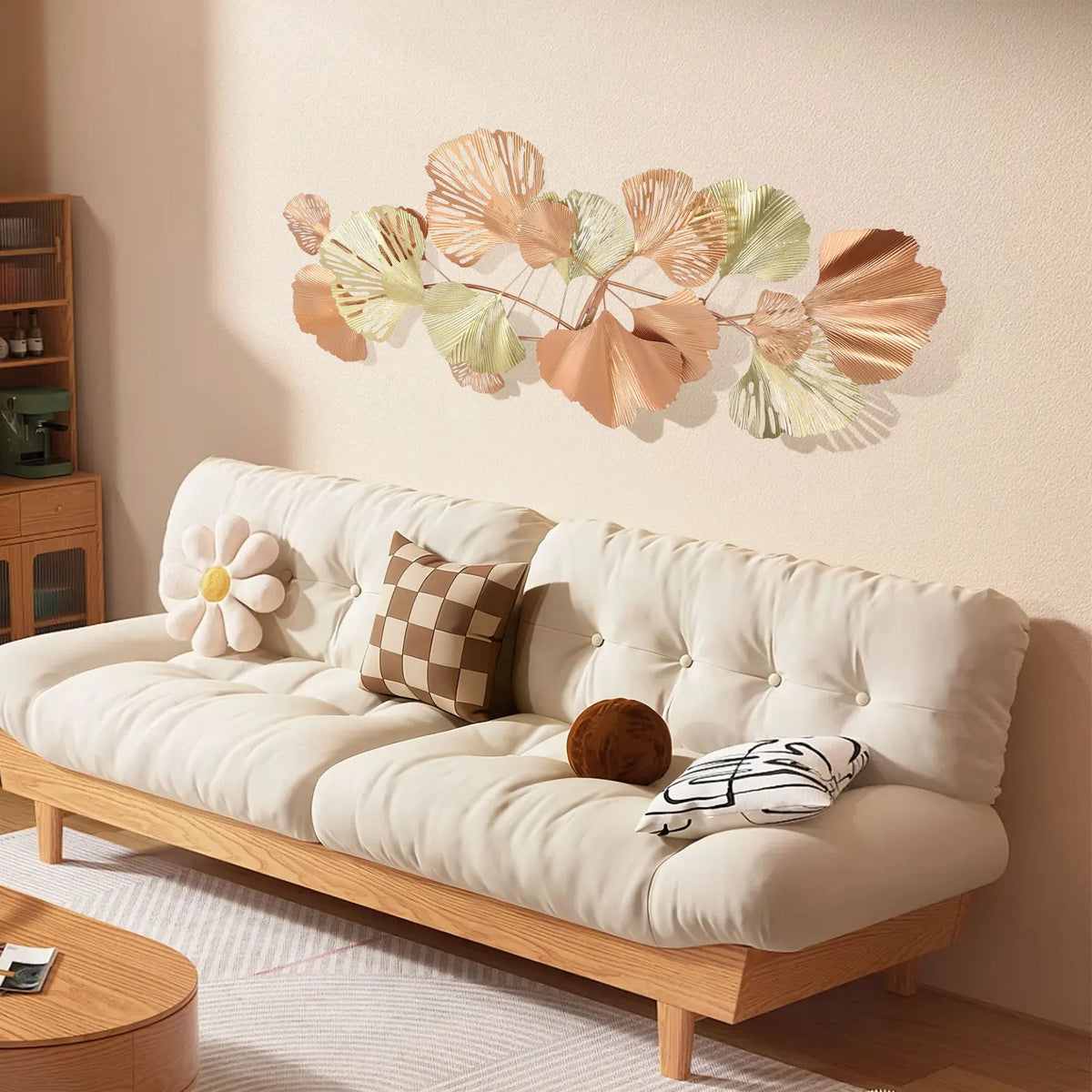 Blush and gold ginkgo leaf wall art above a white sofa