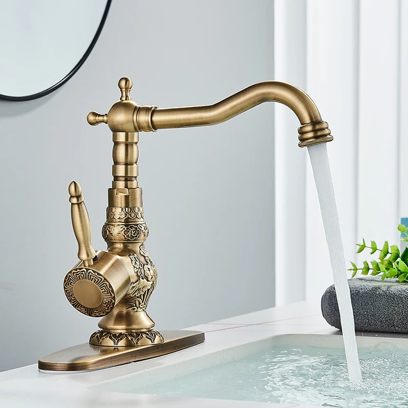 Antique brass ornate carved single-handle faucet on a deck plate pouring into a white basin