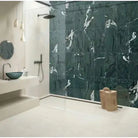Green natural marble vessel sink in a bathroom with matching green marble shower wall