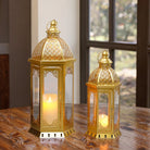 Set of two gold Moroccan candle lanterns with filigree domes and glass panels (on a wood table)