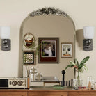 Antique silver baroque arched mirror above a wood console