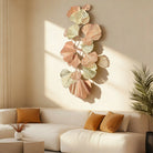 Large ginkgo leaf metal wall art hung vertically above a cream sofa