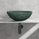 Polished green natural marble vessel sink on a white countertop with black drain