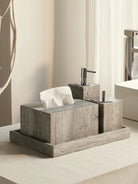 Gray travertine tissue box cover and soap dispensers on a matching travertine tray