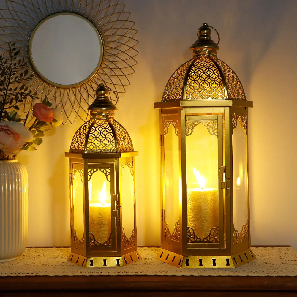 Set of two gold Moroccan candle lanterns with filigree domes and glass panels (glowing in a dim room)