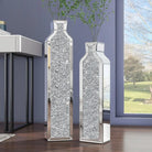 Pair of mirrored crushed-crystal floor vases, 24 and 30 in, by a window
