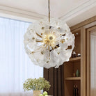 Hand-Blown White Glass Flower Chandelier, 24 in, lit beside a sheer-curtained window
