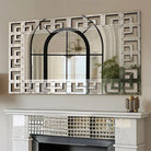 Front view of the Greek-key Venetian mirror's mirrored fretwork border above a mantel