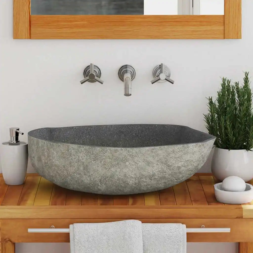 Front view of the gray river-stone vessel sink with rough natural exterior on wood vanity