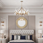 Front view of the starburst mirror's gold-tone glass rays above a bedroom headboard