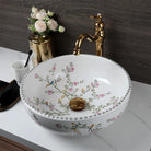 Flower-and-bird porcelain basin seen from above, gold faucet running