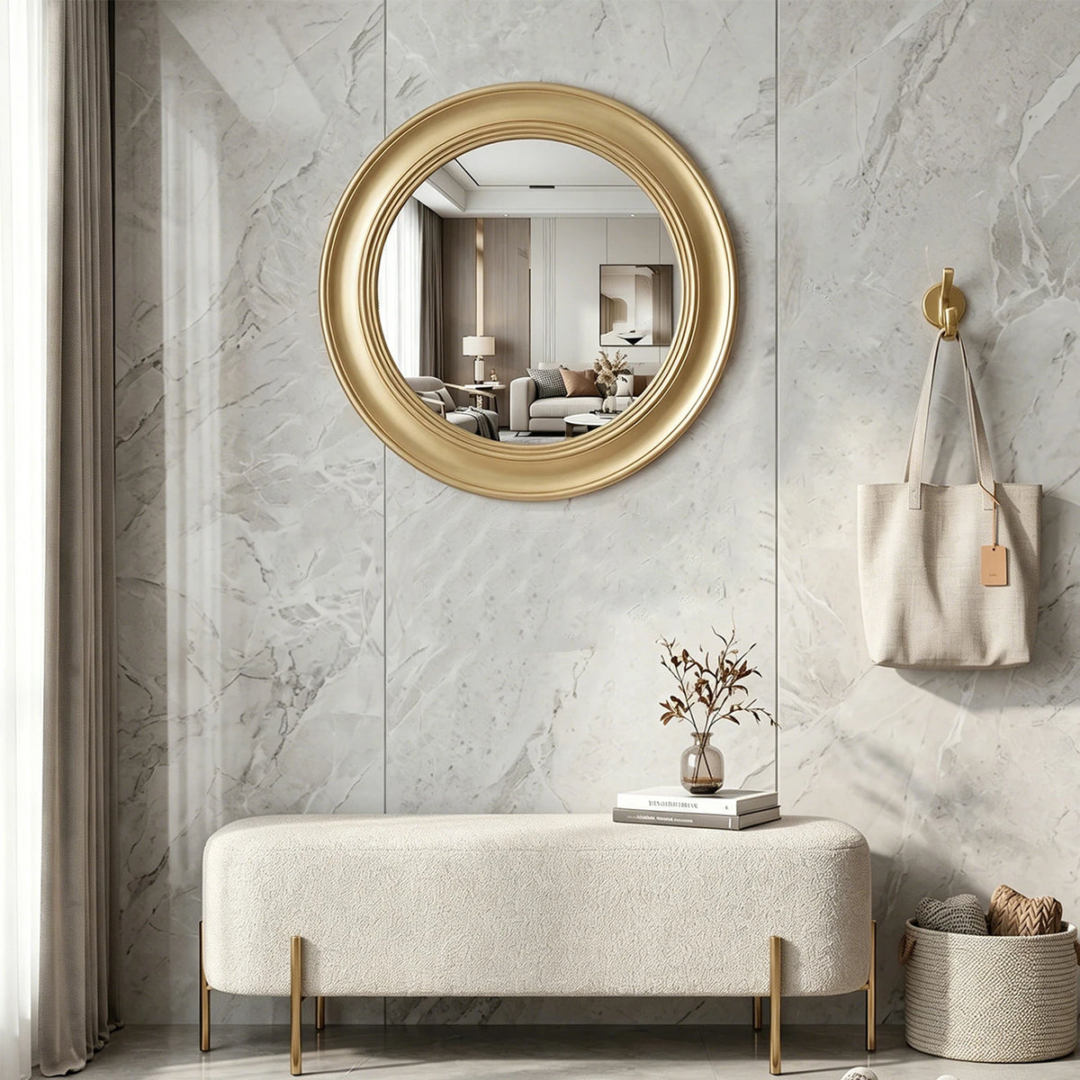 Brushed gold round mirror above an entryway bench