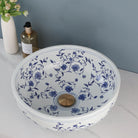 Overhead view of the hand-painted blue floral pattern and gold drain in the ceramic vessel sink