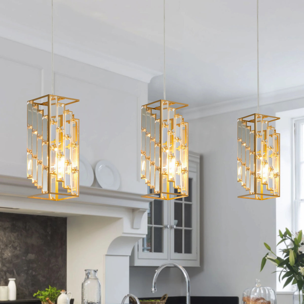 Three gold crystal prism pendant lights over a kitchen island
