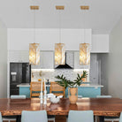 Set of 3 gold crystal pendant lights in a dining area