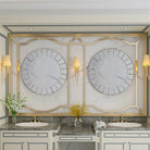 Two Venetian-style round mirrors above a double marble vanity with gold sconces