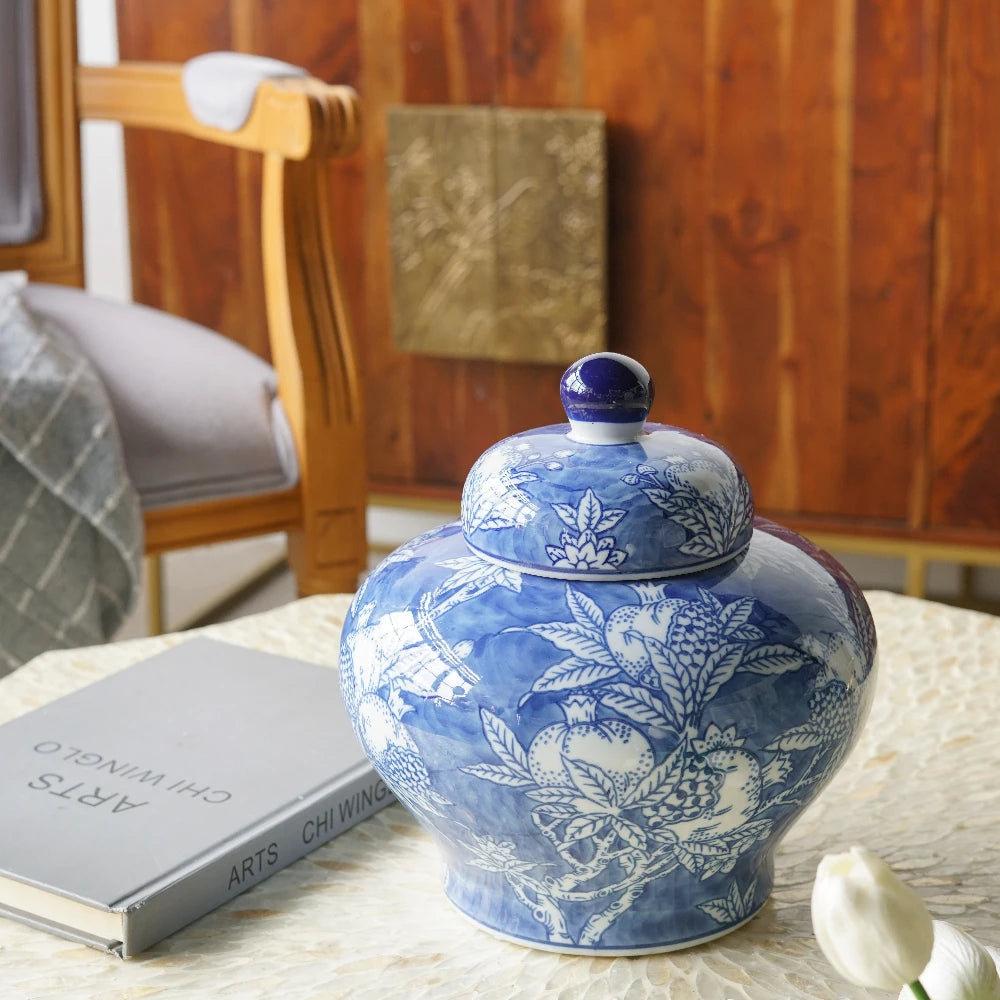 Blue and white lidded jar on a table beside a book