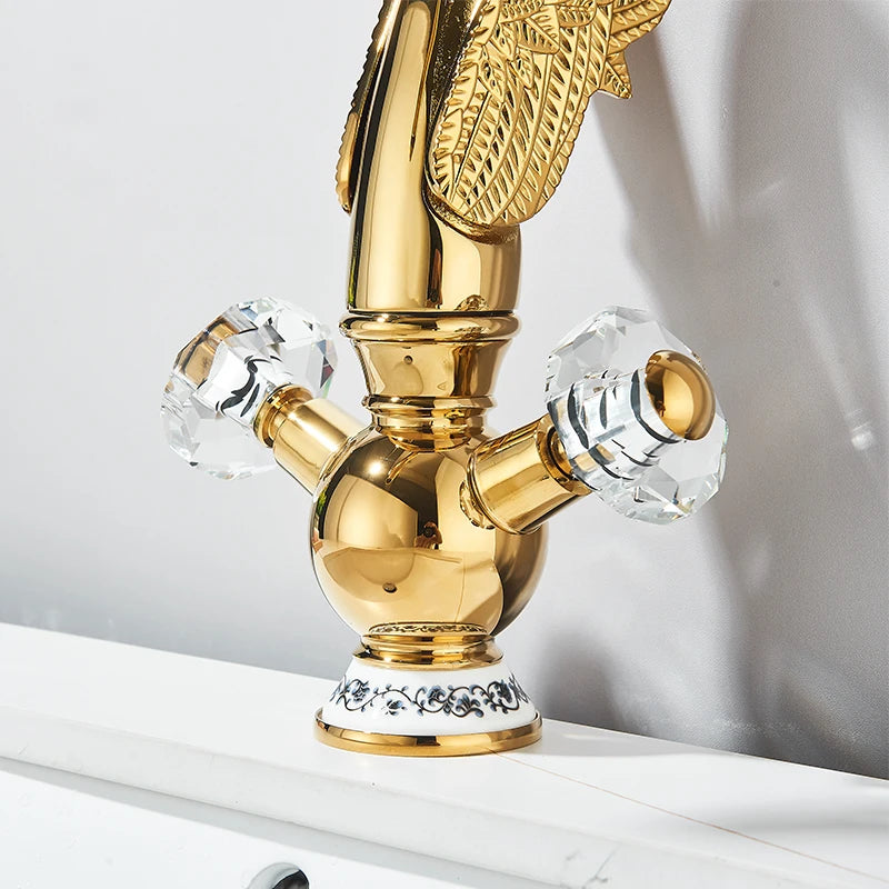 Gold swan-neck basin faucet with two crystal handles and white porcelain base