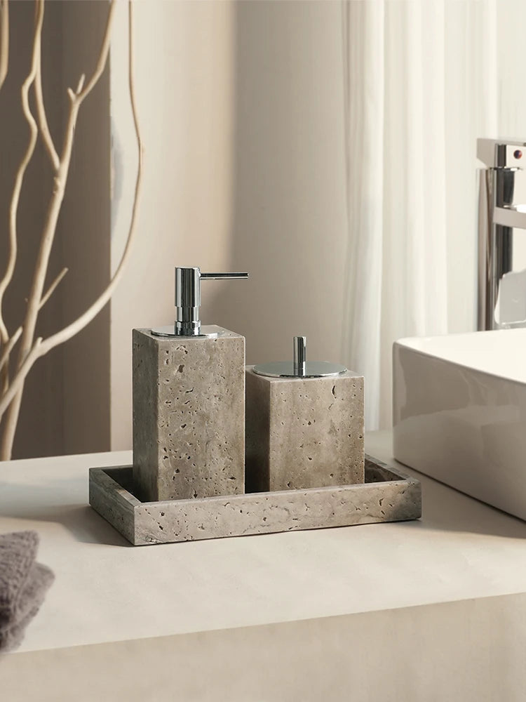 Square gray travertine soap dispenser and tumbler with silver-tone pump on a tray