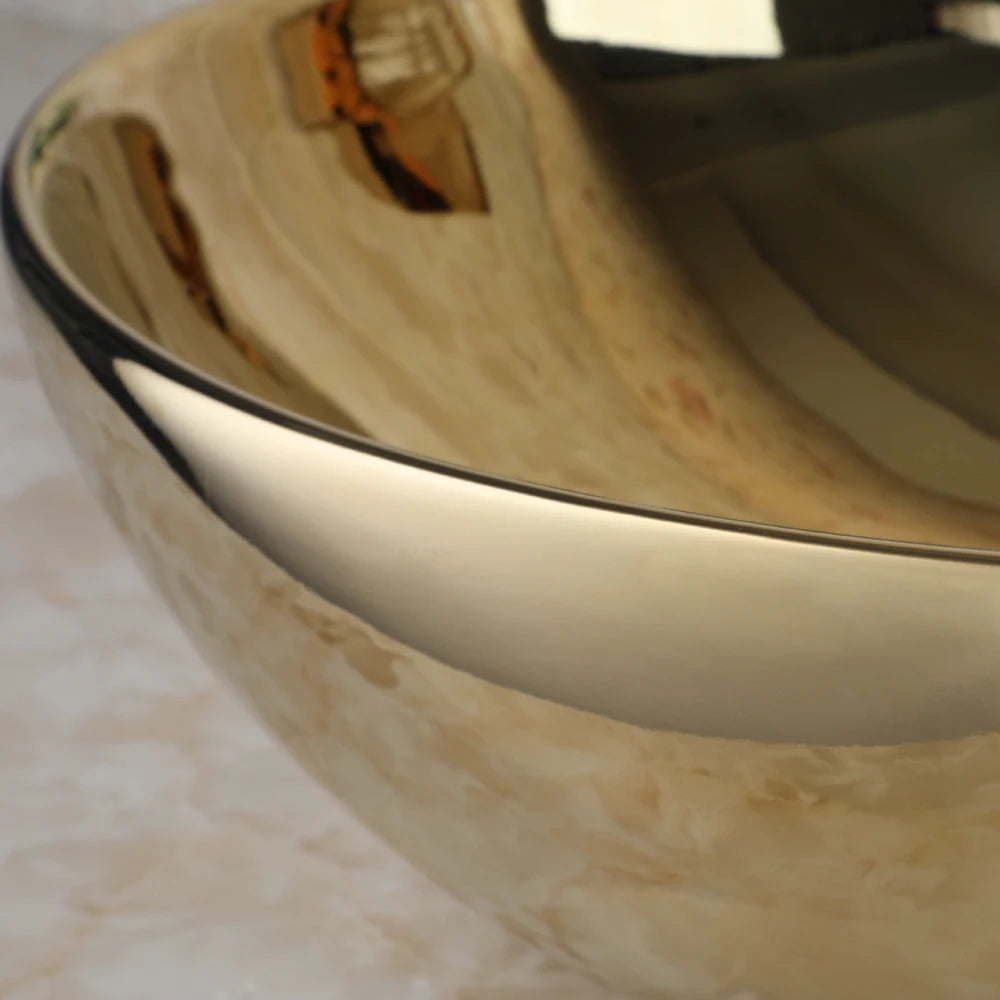 Close-up of the mirror-like polished gold glaze on the round ceramic vessel sink rim