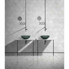 Pair of green marble vessel sinks on open metal stands below wall-mount faucets