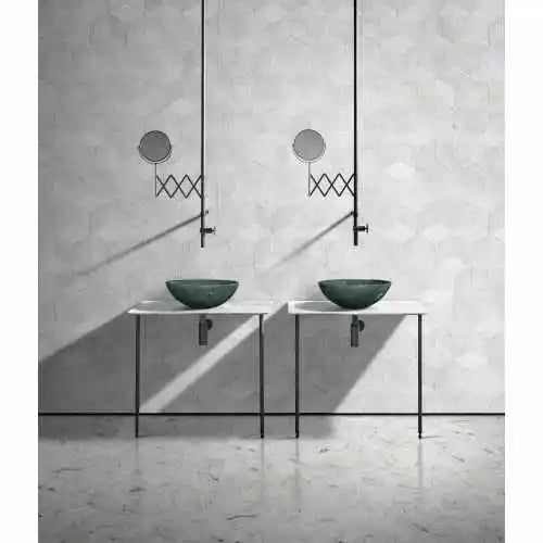 Pair of green marble vessel sinks on open metal stands below wall-mount faucets