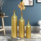 Gold floor vases against a blue wall