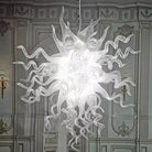Hand-blown milk-white glass art chandelier with swirling glass arms lit against paneled walls