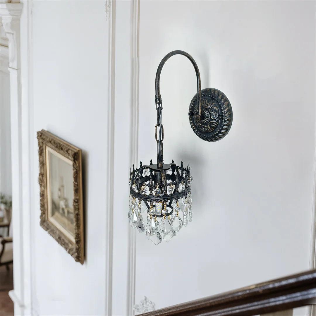 Side view of the crystal wall sconce with black iron gooseneck arm and round backplate