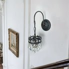 Side view of the crystal wall sconce with black iron gooseneck arm and round backplate