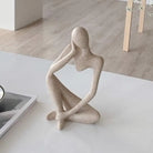 Close-up of the sandstone-finish thinker sculpture showing its textured abstract figure