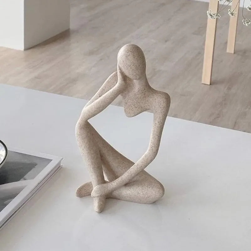 Close-up of the sandstone-finish thinker sculpture showing its textured abstract figure
