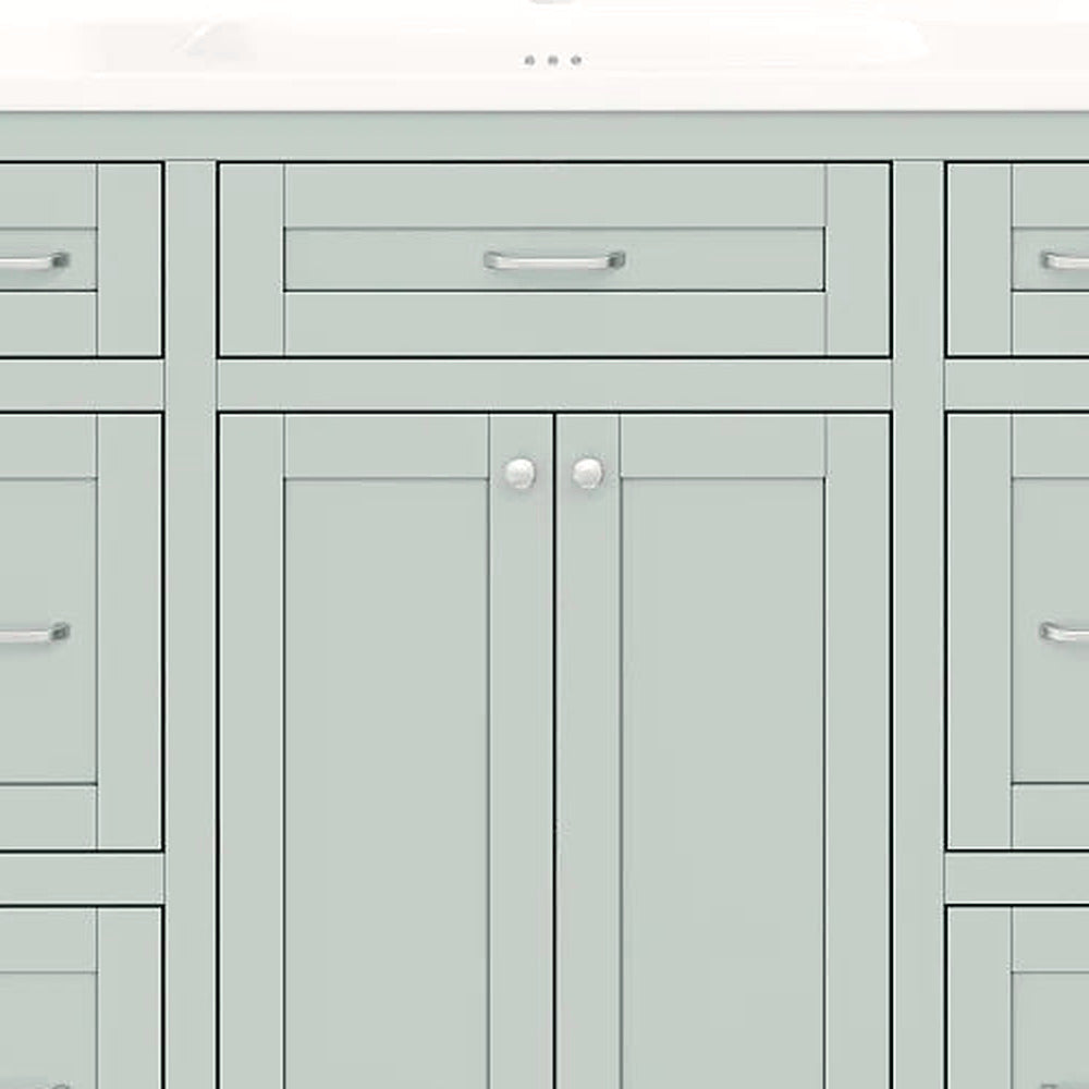 Close-up of the slim silver pulls and shaker paneling on the mint green vanity