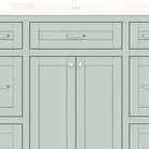 Close-up of the slim silver pulls and shaker paneling on the mint green vanity