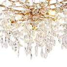 Close-up of the cascading faceted crystal strands catching warm light on the gold branch chandelier