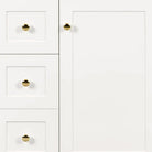 Close-up of the shaker door, drawers and round gold knobs