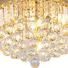 Close-up of rectangular crystal prisms and faceted crystal spheres on the gold drum flush mount