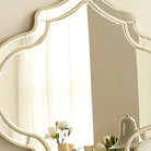 Close-up of the gold quatrefoil frame and beveled mirror border